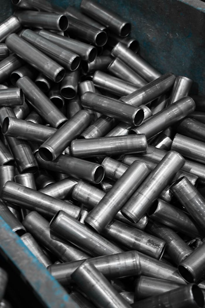 Vertical shot of stainless steel pipes stacked in an industrial container.